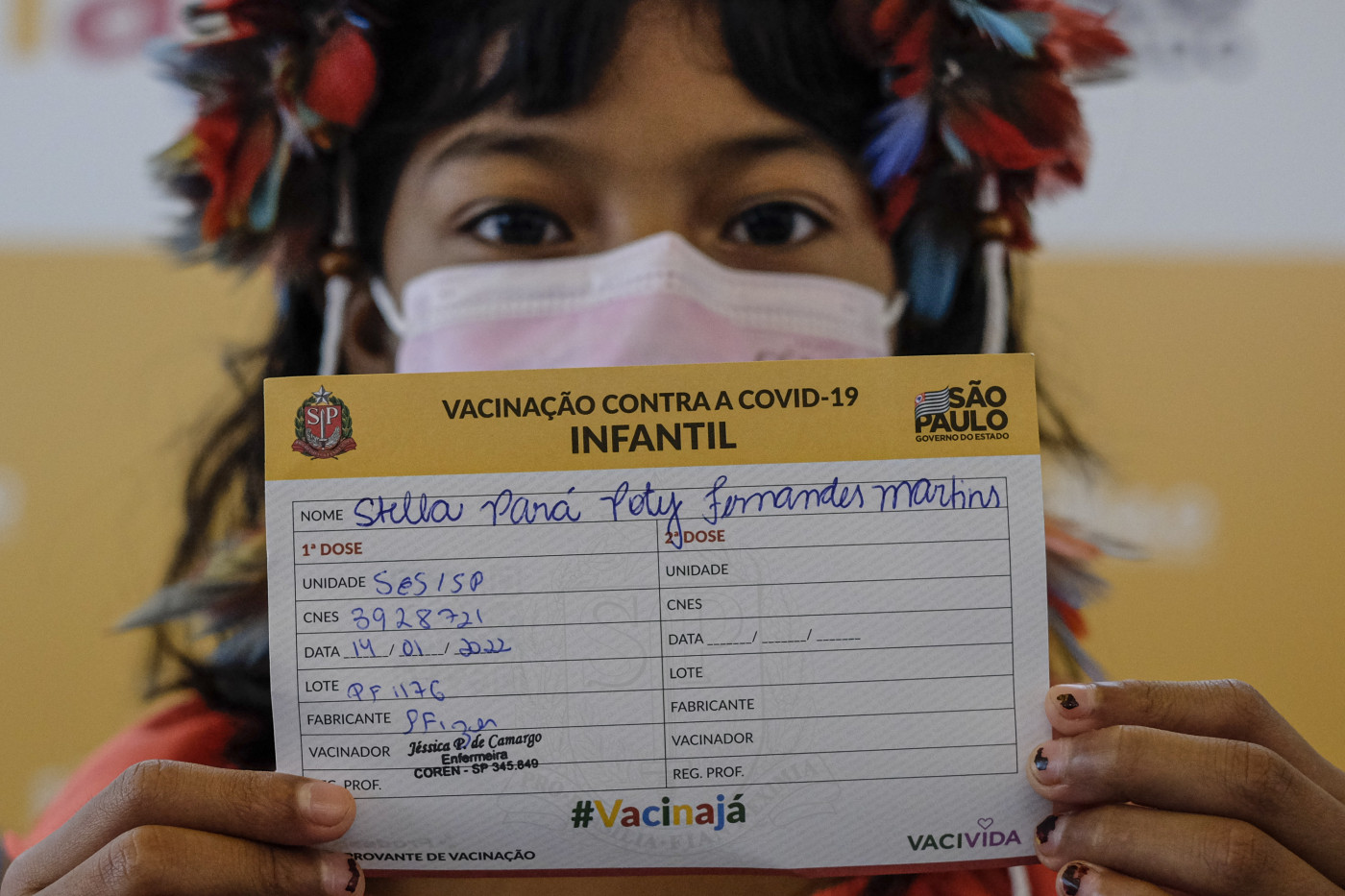 Criança indígena da etnia Poty mostra comprovante da vacina