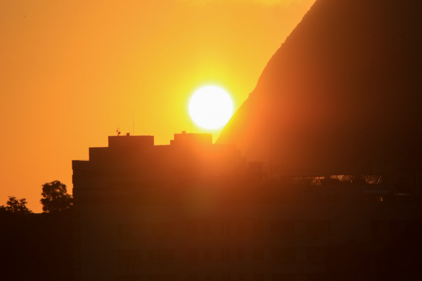 Detalhe do sol nascendo com vista do Pão de Açúcar a partir do bairro das Laranjeiras, na zona sul do Rio de Janeiro