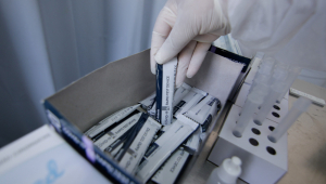 Mão de enfermaria pegando testes de Covid-19 em uma caixa