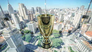 Taça do Campeonato Paulista colocada perto de uma janela com vista panorâmica para a cidade de São Paulo