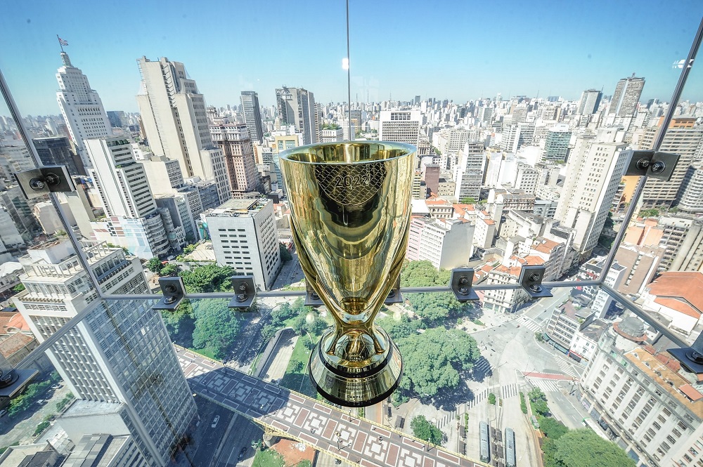 Taça do Campeonato Paulista colocada perto de uma janela com vista panorâmica para a cidade de São Paulo