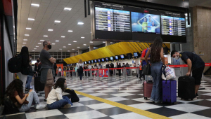 Pessoas sentam no chão de aeroporto após voos serem cancelados