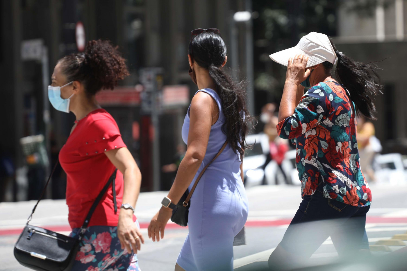 Pedestres se protegem do calor no Viaduto do Chá em São Paulo