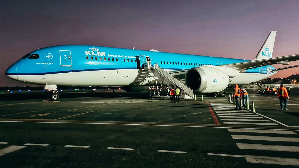 Avião da empresa KLM parado na pista de um aeroporto durante a noite