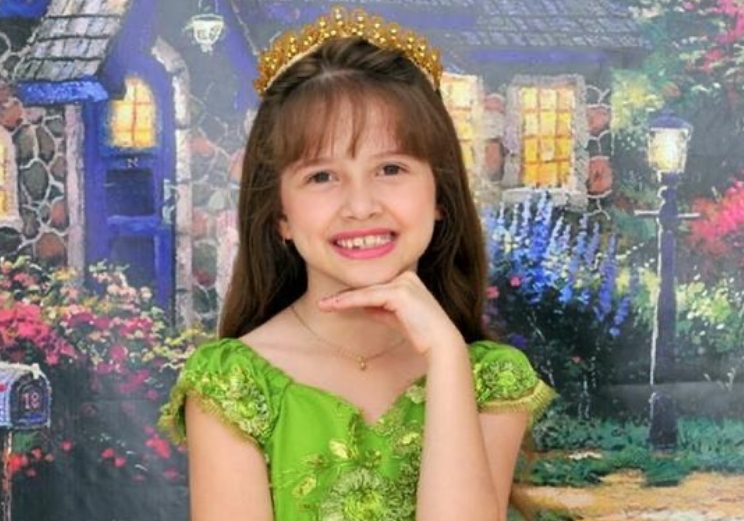 Menina Beatriz: Menina com vestido verde e coroa posando para a foto com a mão no queixo