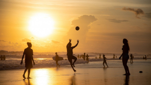Pessoas jogando bola na área da praia