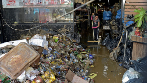 Uma mulher limpa dentro de um supermercado que foi atingido por fortes inundações em Petrópolis