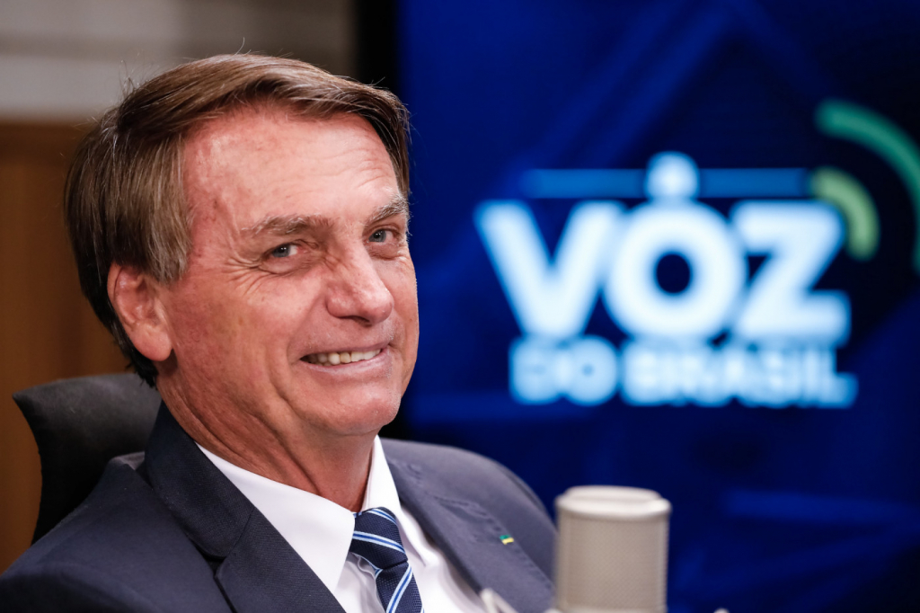 Jair Bolsonaro sorri enquanto participa do programa de rádio "Voz do Brasil"