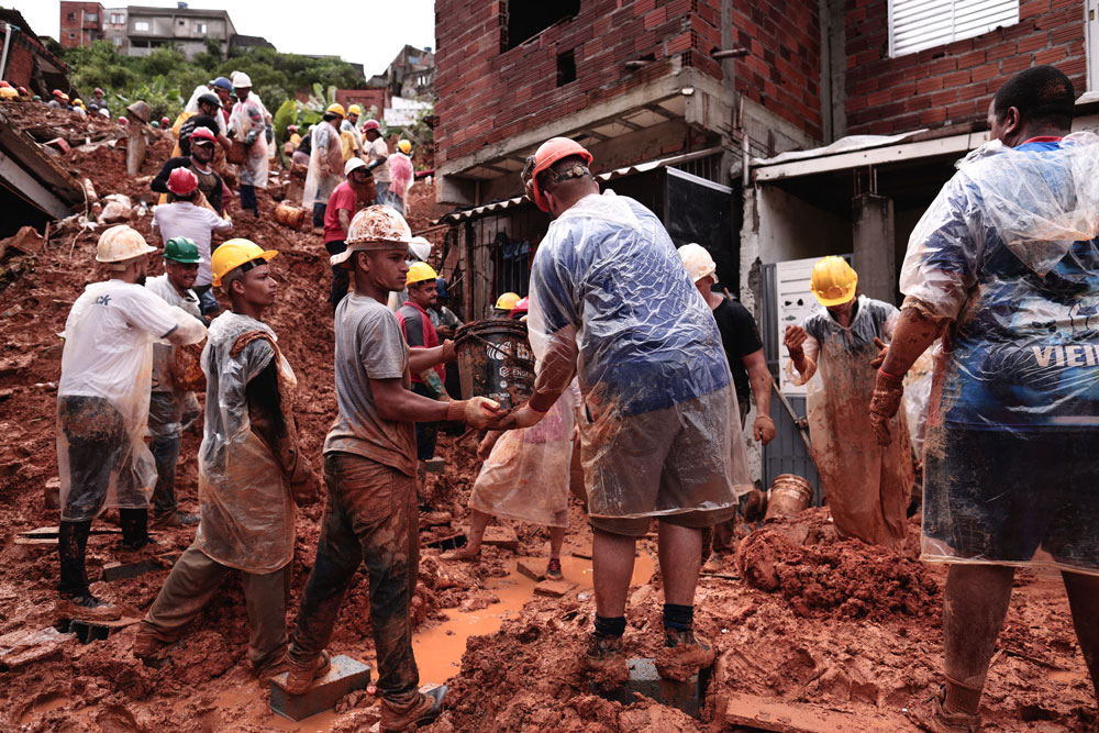 Voluntários auxiliam bombeiros durante busca a sobreviventes de deslizamento de terra em Franco da Rocha, região metropolitana da cidade de São Paulo