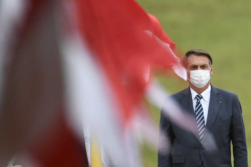 Jair Bolsonaro caminha em meio a bandeiras no evento de abertura do ano legislativo