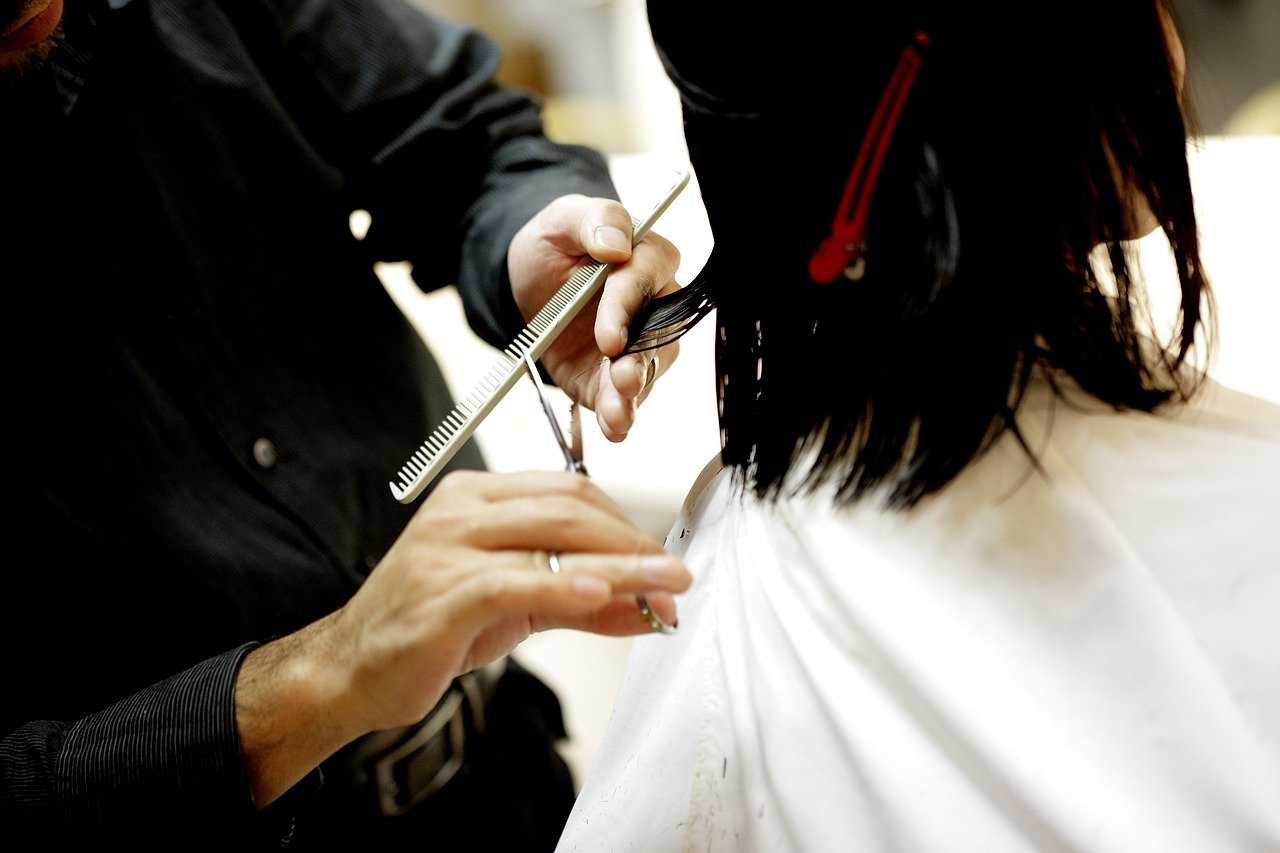 Cabeleireira cortando o cabelo de uma mulher