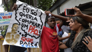 Yago Corrêa ergue cartaz que sua família havia protestado contra sua prisão, com a mensagem 'Eu só queria comprar um pão. Que país é esse?'