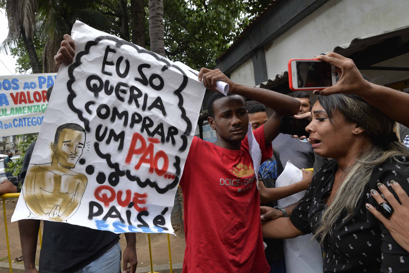 Yago Corrêa ergue cartaz que sua família havia protestado contra sua prisão, com a mensagem 'Eu só queria comprar um pão. Que país é esse?'