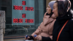 Mulheres passam em frente casa de câmbio em Moscou