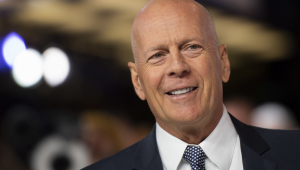 Bruce Willis de terno durante tapete vermelho de cerimônia