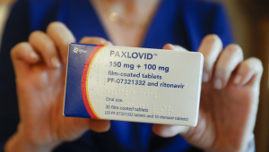 Mulher segura caixa do medicamento Paxlovid