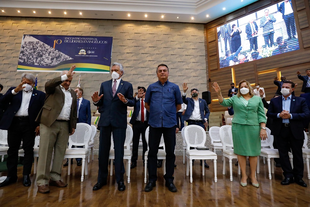 O presidente Jair Bolsonaro, de calça preta e camisa azul escura, ao lado de líderes evangélicos em culto em Goiás