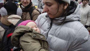 Mulher segura bebê no colo durante evacuação de civis perto de Kiev