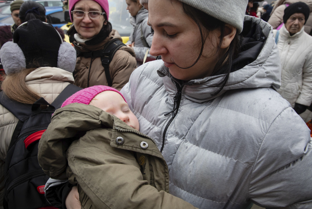 Mulher segura bebê no colo durante evacuação de civis perto de Kiev