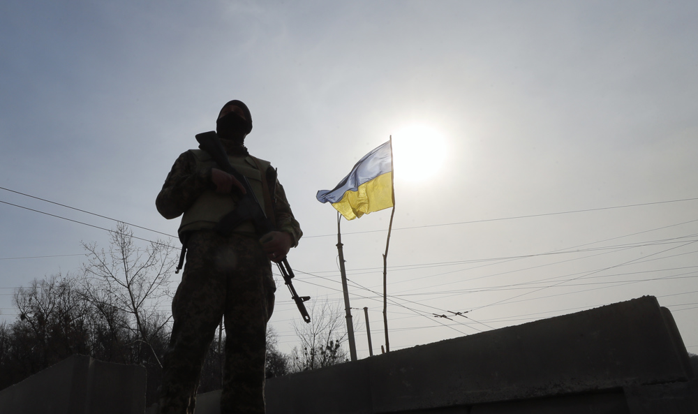 Soldado em frente à bandeira da Ucrânia