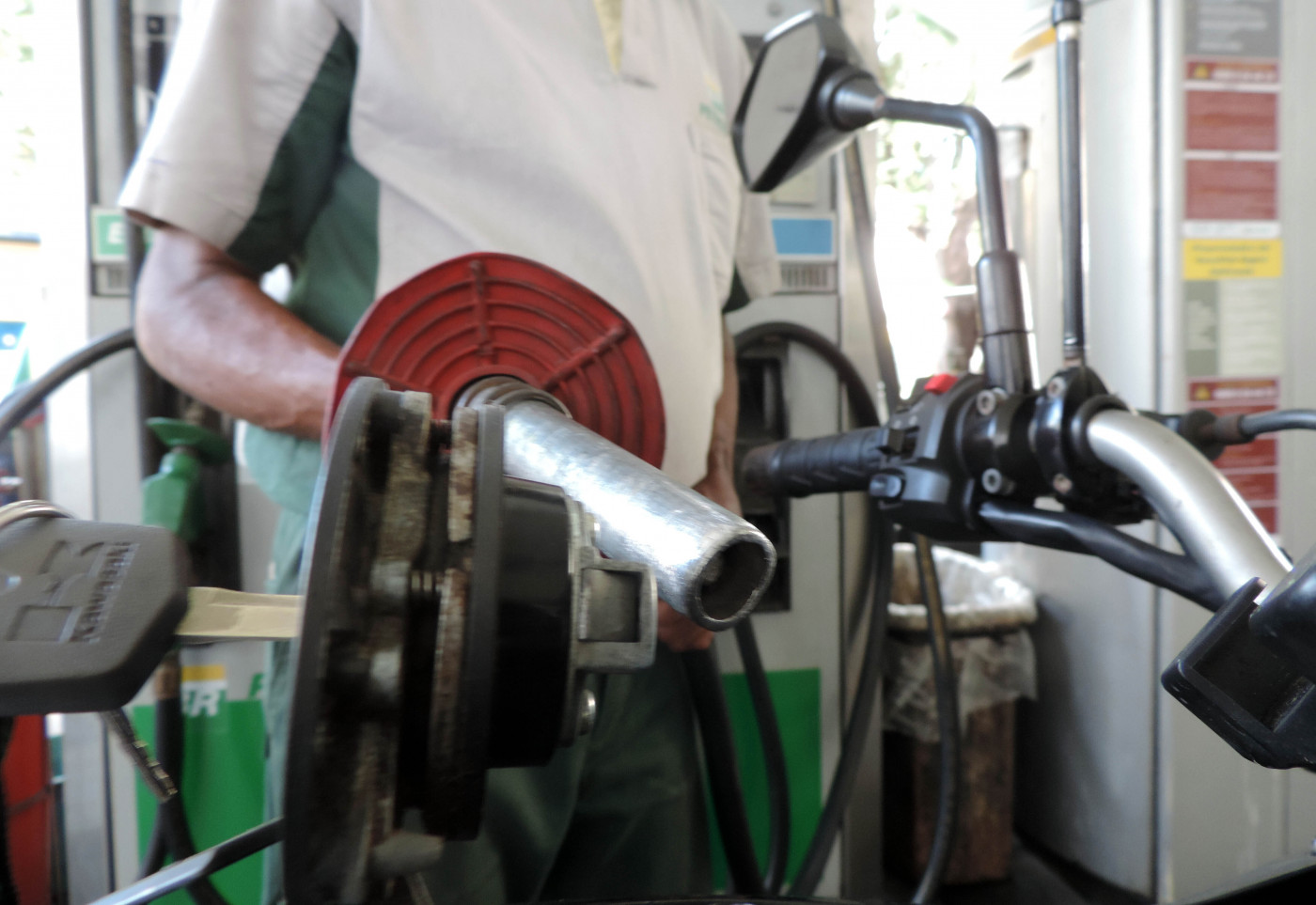 Frentista atrás de bombas no posto de gasolina