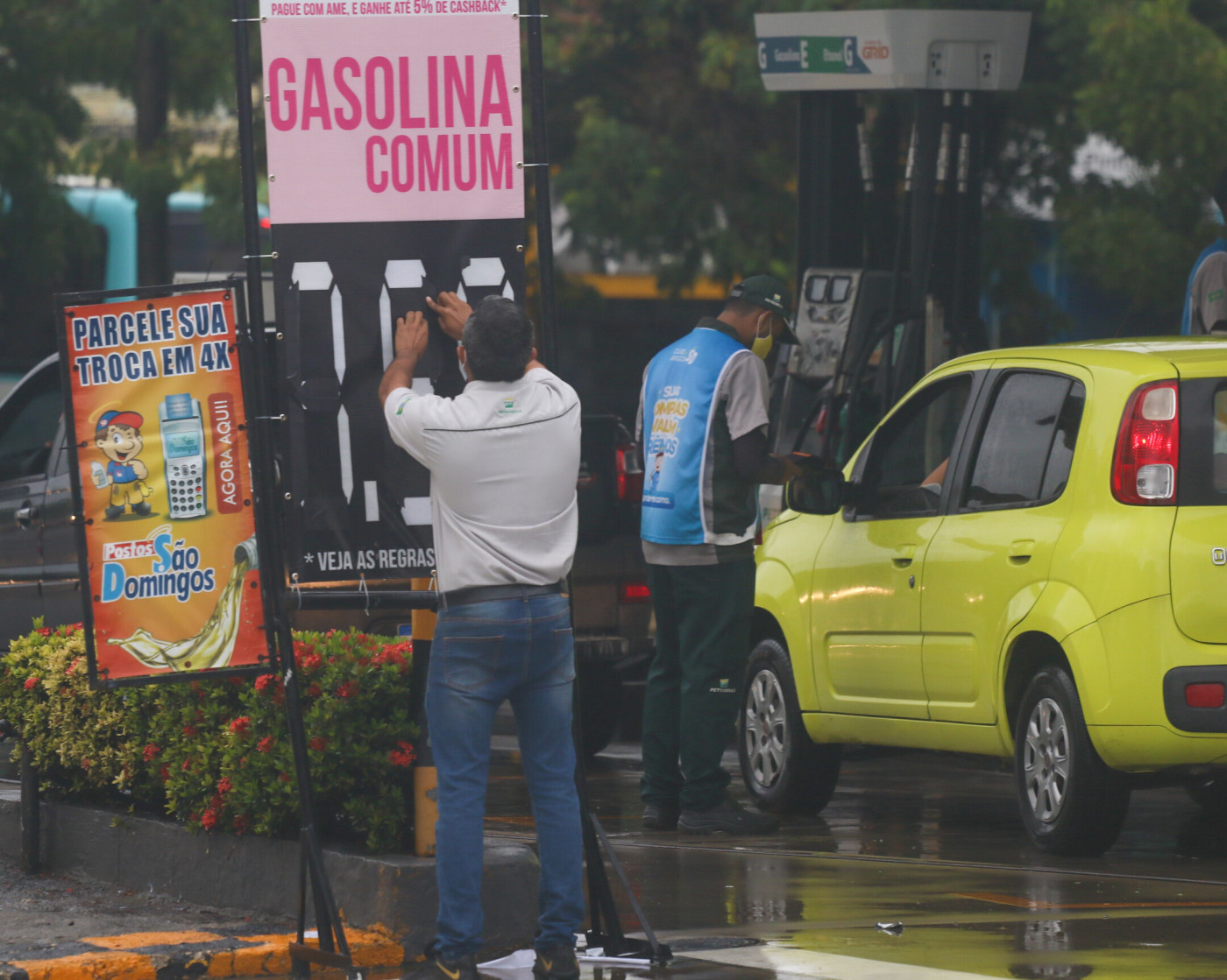 Homem muda indicação de preço da gasolina em placa de posto de combustível em Fortaleza