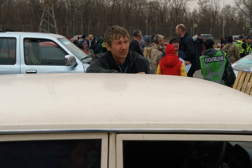 Homem se encosta em carro na fila de civis que tentam fugir de Mariupol
