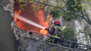Bombeiros tentam apagar um incêndio em um prédio residencial após bombardeio no centro de Kharkiv