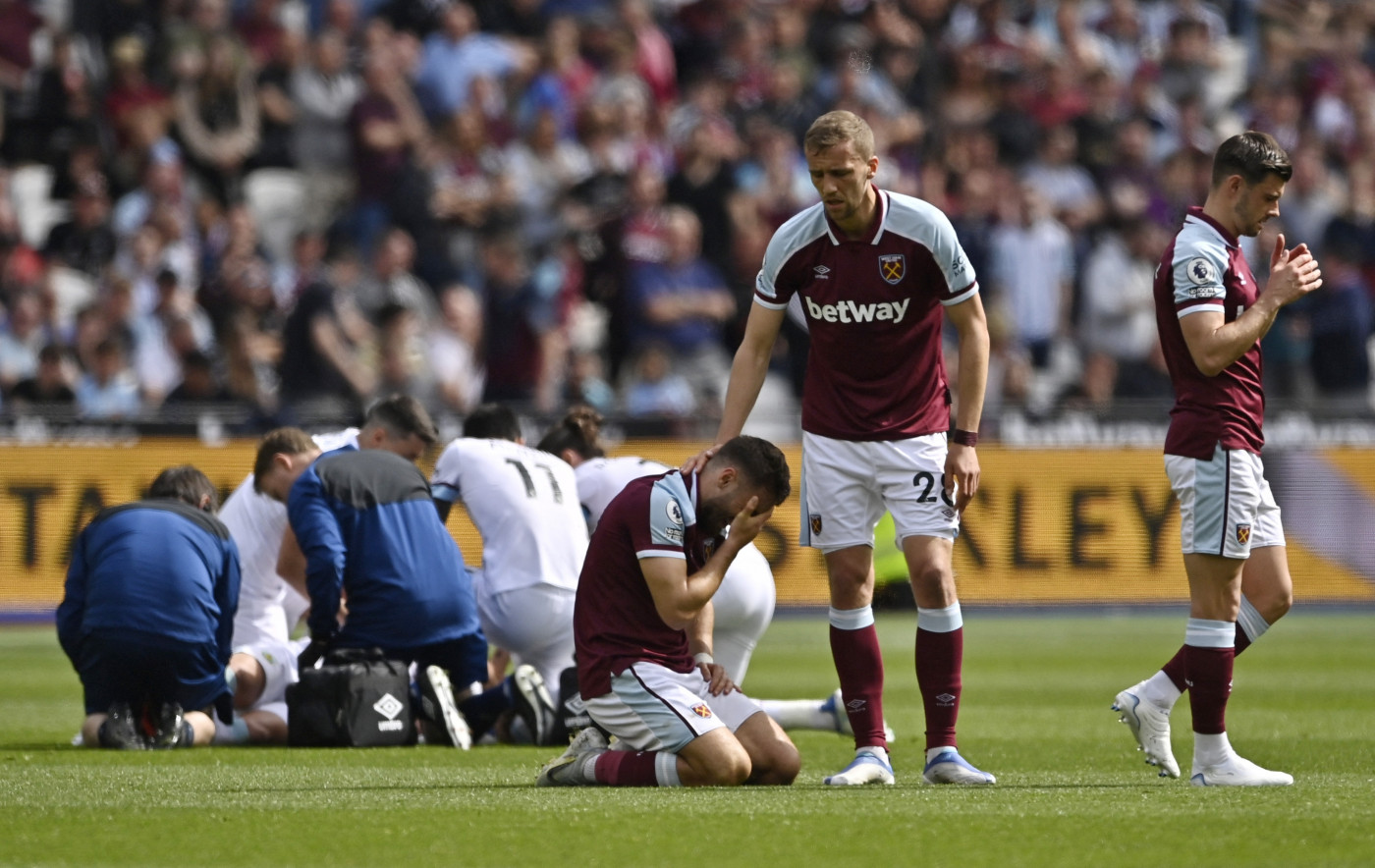 Nikola Vlasic, do West Ham United, é consolado por Tomas Soucek, enquanto Ashley Westwood, do Burnley, recebe atendimento médico após sofrer uma lesão