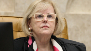 A ministra Rosa Weber sentada em sua cadeira e usando um óculos com armação amarela