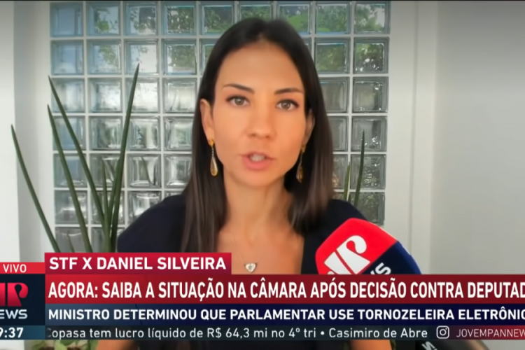 Frame do Jornal da Manhã com Amanda Klein na tela, o microfone da Jovem Pan à direita e uma tarja discorrendo sobre a briga entre o deputado Daniel Silveira e o STF