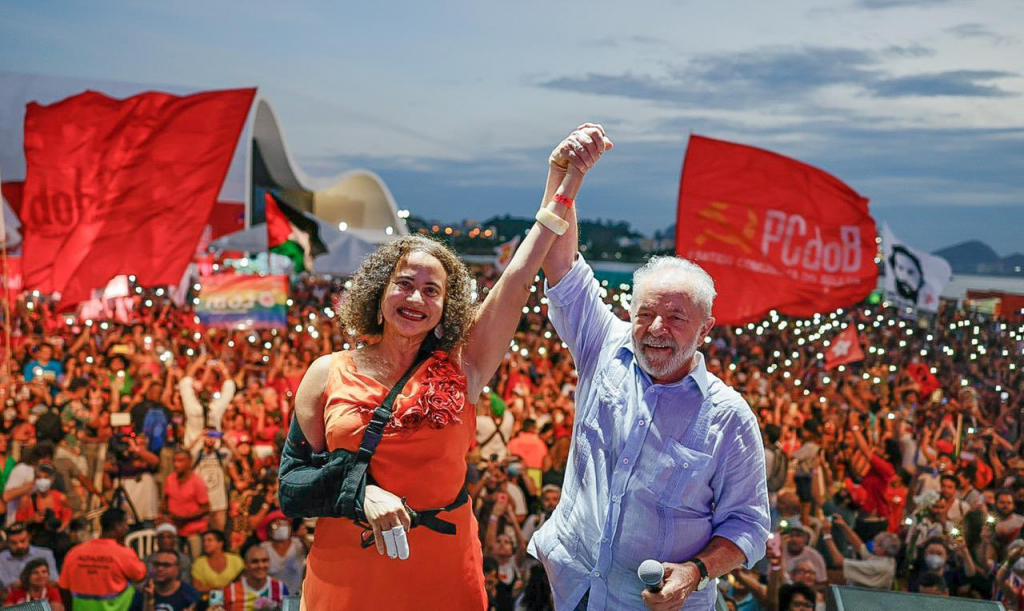 Presidente Nacional do PCdoB, Luciana Santos, e o ex-presidente Lula segurando as mãos erguidas