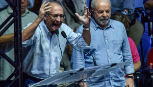 Geraldo Alckmin berrando com as mãos para o alto ao lado de Lula