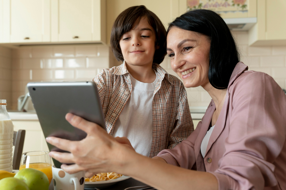 Mãe e filho olhando em um tablet na cozinha, ambos sorrindo