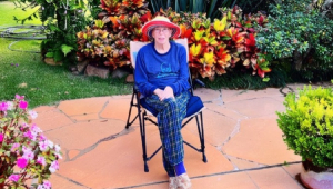 Rita Lee sentada em cadeira em meio a jardim