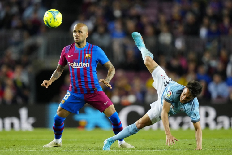 Daniel Alves, do Barcelona, estufa o peito para matar a bola enquanto Cervi, do Celta, cai após tentar saltar