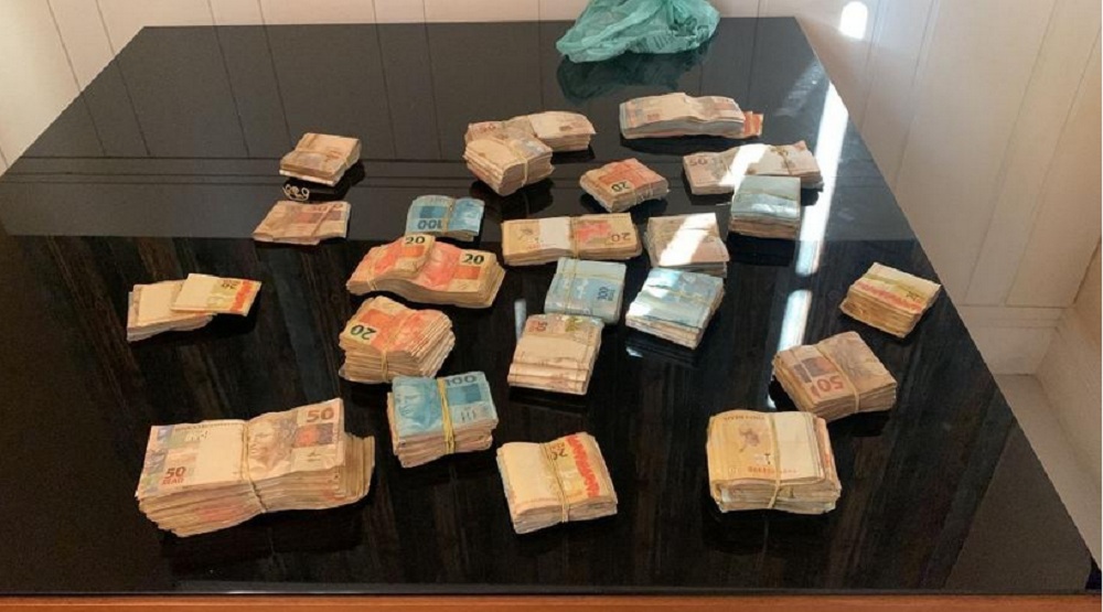 Maços de dinheiro apreendidos em operação do Ministério Público sobre uma mesa