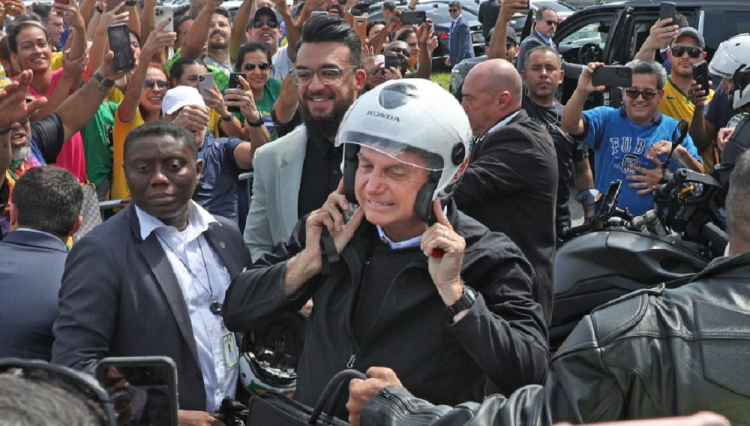 Cercado por apoiadores, Bolsonaro tira capacete após motociata