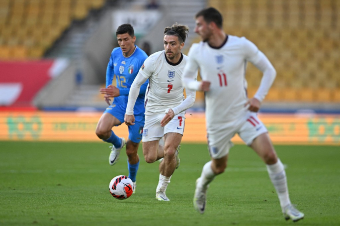Jogador inglês avança com a bola enquanto italiano o acompanha de perto
