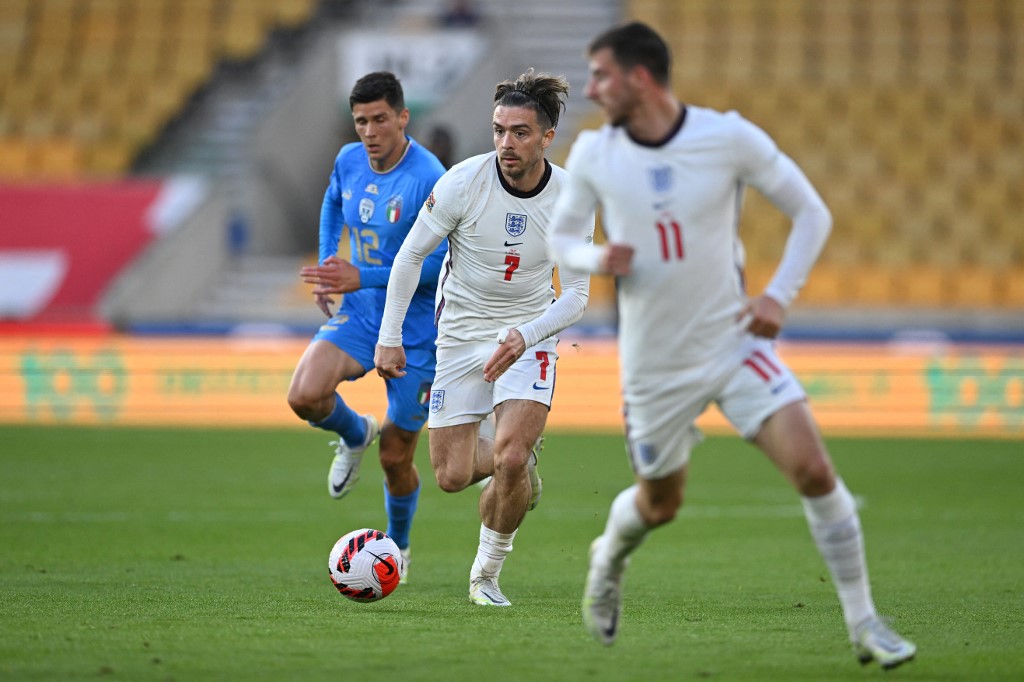 Jogador inglês avança com a bola enquanto italiano o acompanha de perto