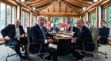 Sentados ao redor de uma mesa em um requintado, porém rústico, cômodo de um castelo na Alemanha, líderes do G7 olham para a câmera e sorriem