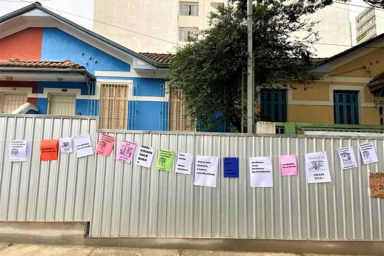 Cartazes colados em proteção de alumínio que cerca casas em Pinheiros