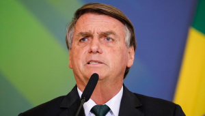 Jair Bolsonaro, de terno e gravata, fala em microfone