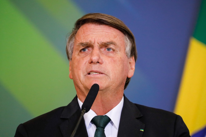 Jair Bolsonaro, de terno e gravata, fala em microfone