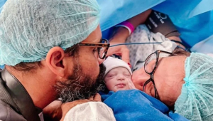 Juliano Cazarré e Leticia Bastos beijando a filha após o seu nascimento