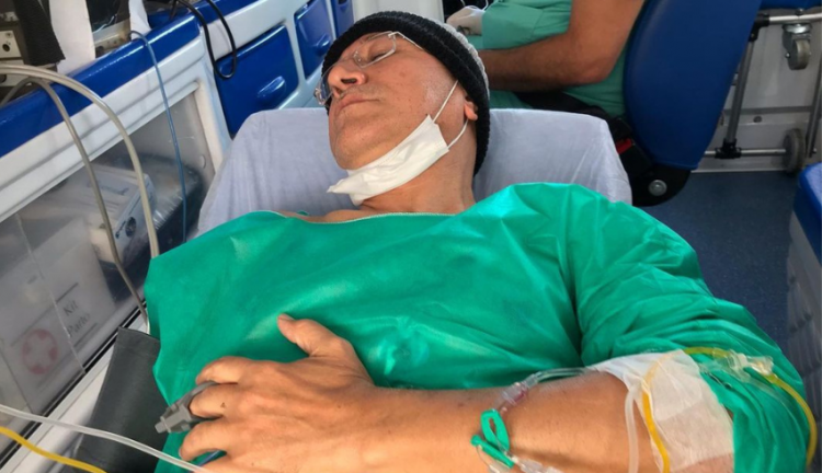 Sergio Lopes deitado em uma maca de hospital