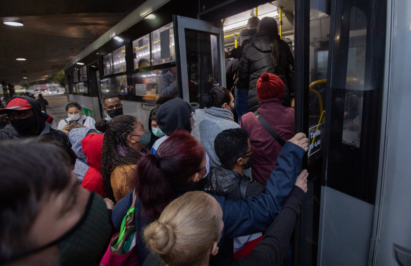 Passageiros tentam entrar em ônibus