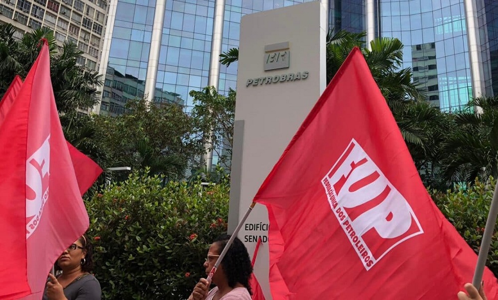 Sindicalistas carregam bandeira vermelha da Frente Única dos Petroleiros em frente à sede da empresa no Rio de Janeiro