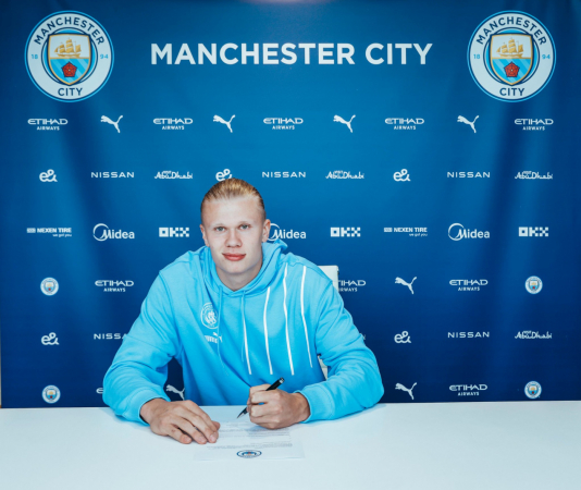 Erling Haaland assinando contrato com o Manchester City