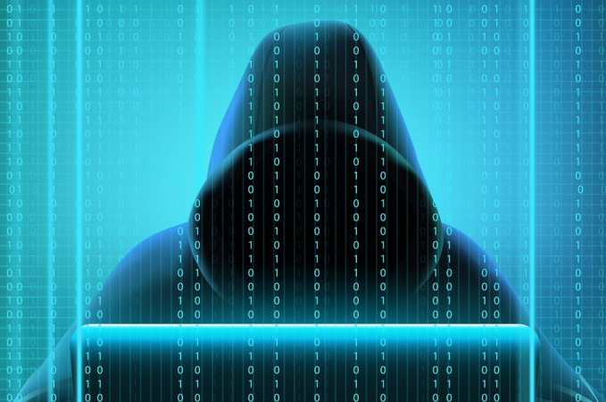 An enigmatic figure in a hood, whose face does not appear, fiddles with the computer as codes permeate the grim image